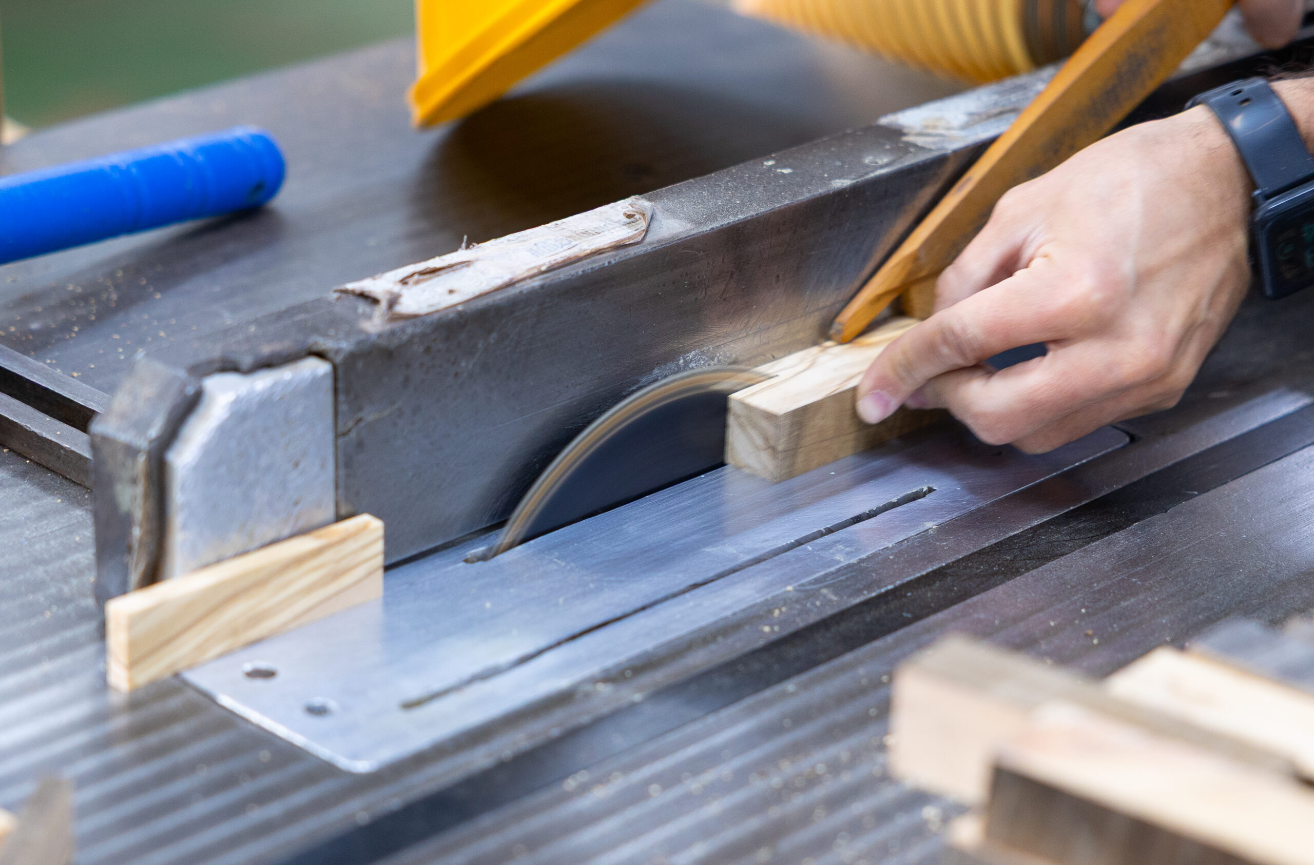 Worker cutting pieces of natural wood for handles