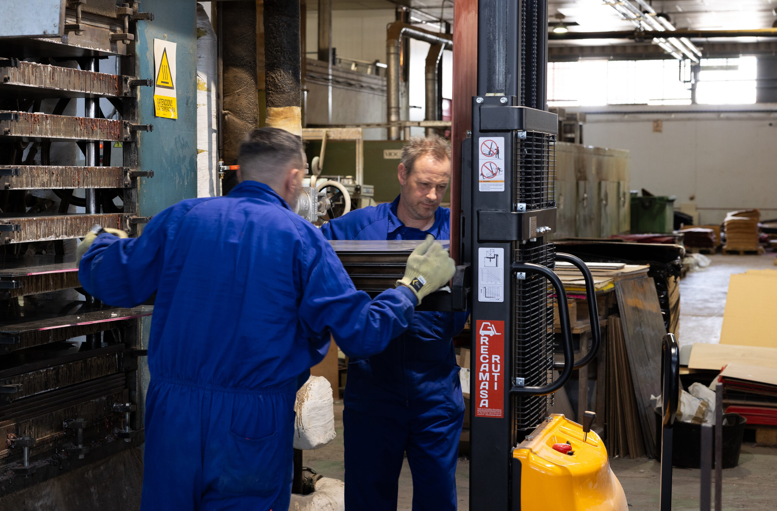 Workers loading a forklift at the factory workshop