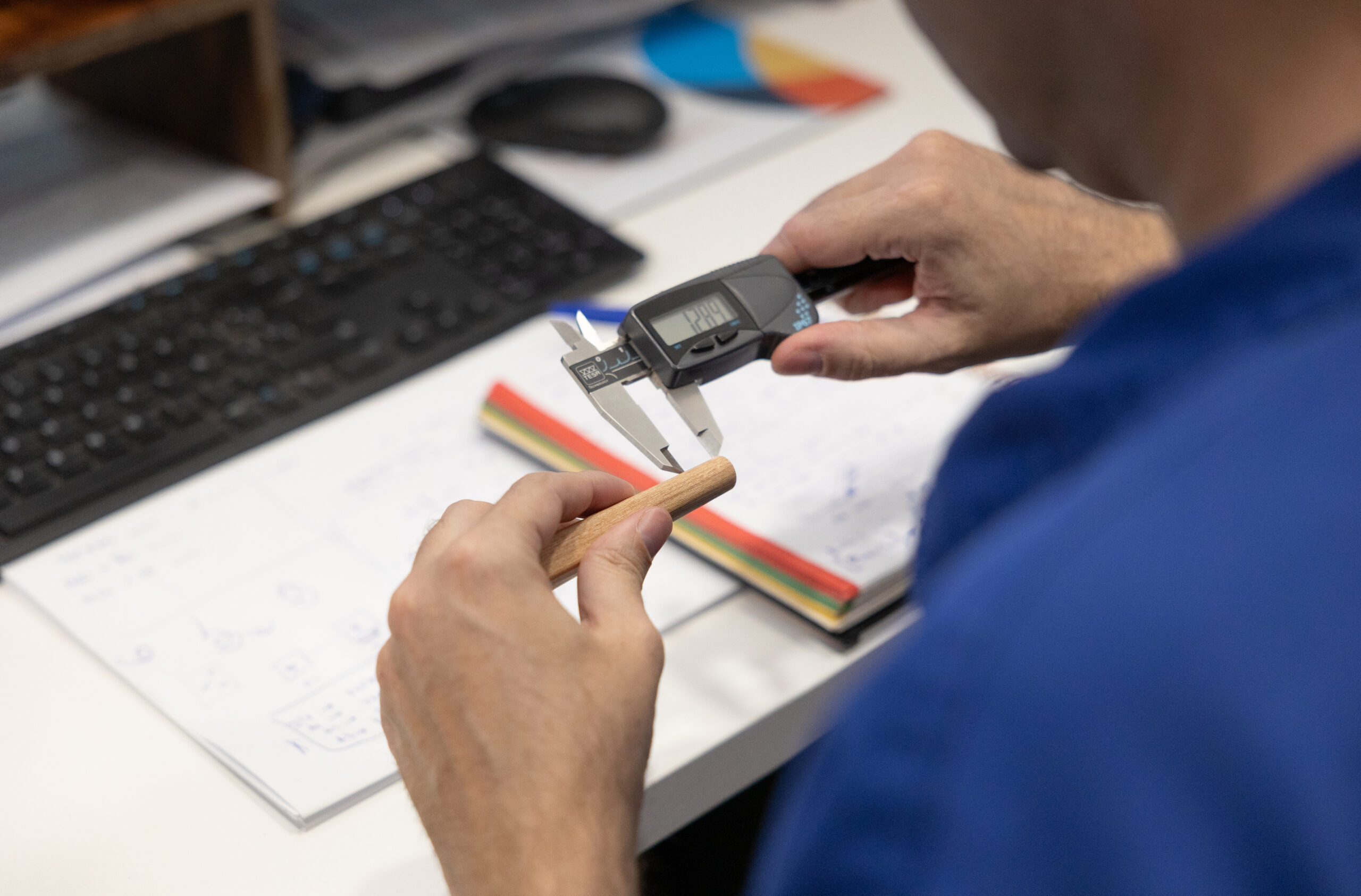 Worker measuring a wooden handle