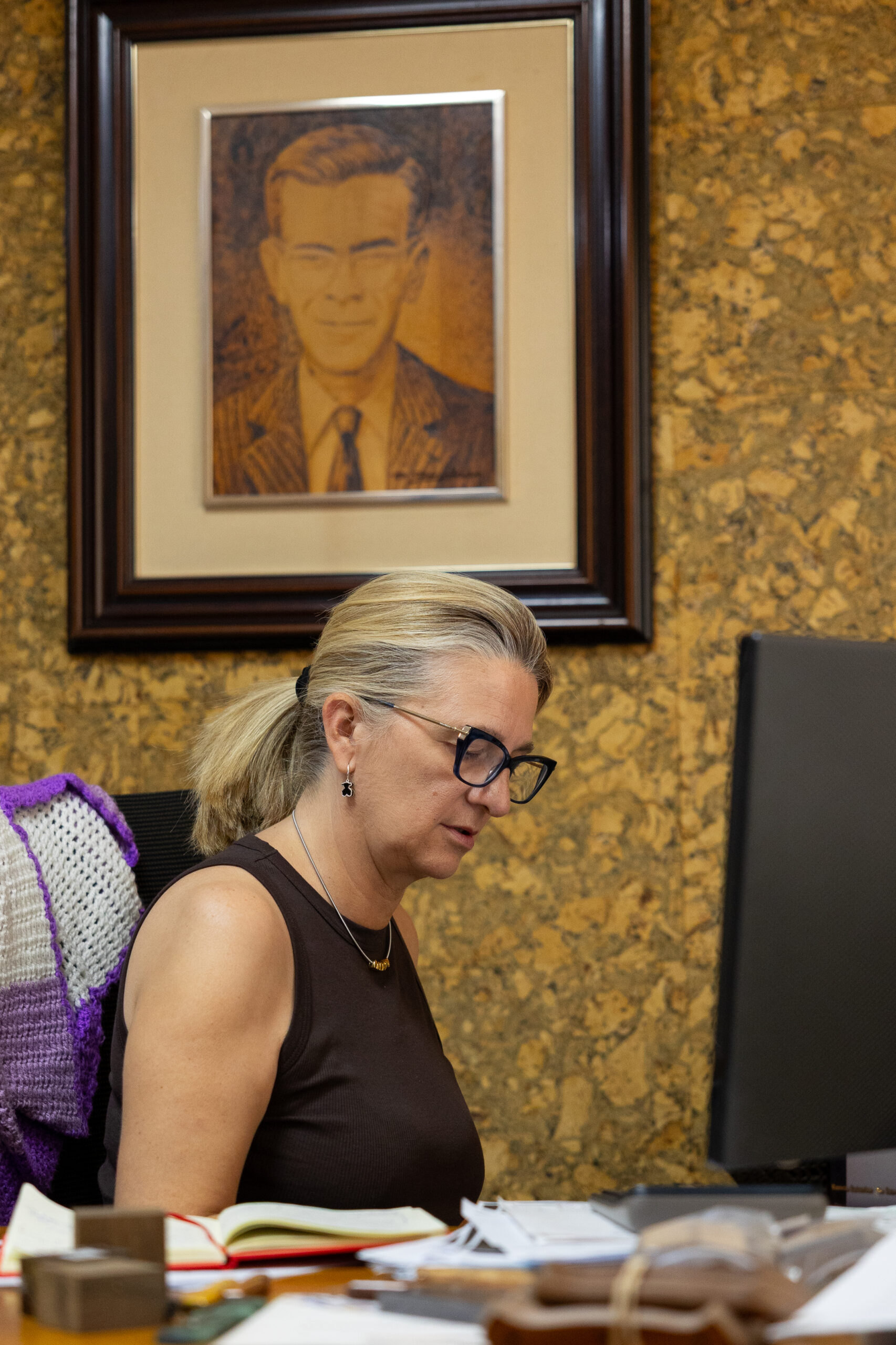 Ana Nunez in her office with a portrait of her ancestor Julian Nunez